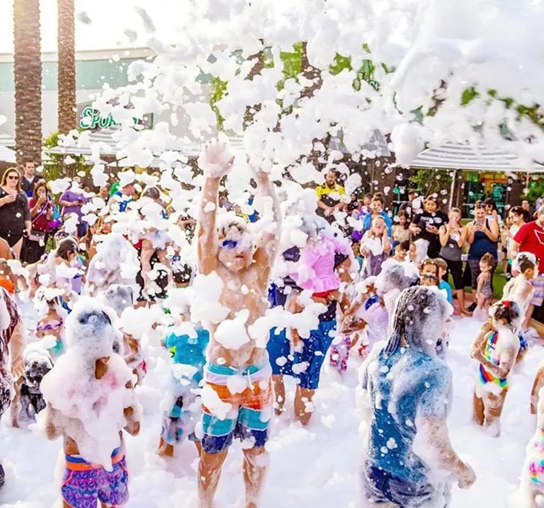 Aerial view of a large crowd enjoying a neighborhood foam party