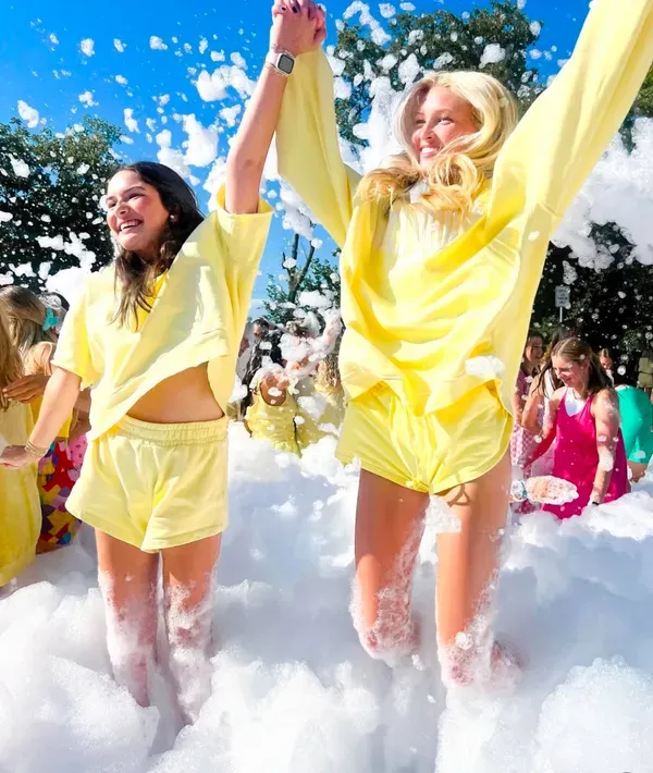 Teens jumping and celebrating at a foam party